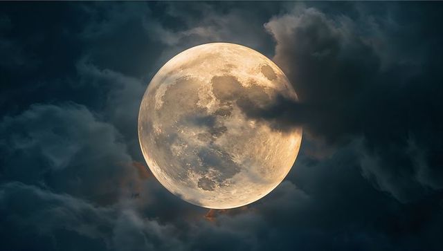 Glowing Full Moon with Atmospheric Clouds in Dark Night Sky