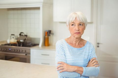 Senior Woman in Modern Kitchen with Thoughtful Expression