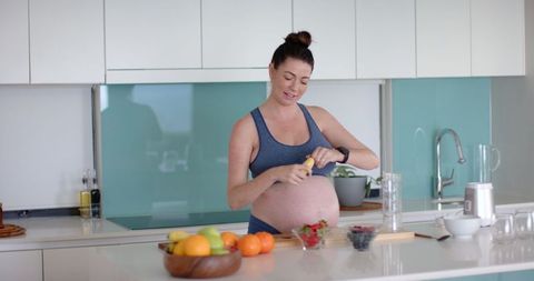 Pregnant Woman Preparing Smoothie in Modern Kitchen