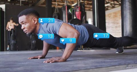Black man performing full-body pushup in industrial gym with social engagement badges