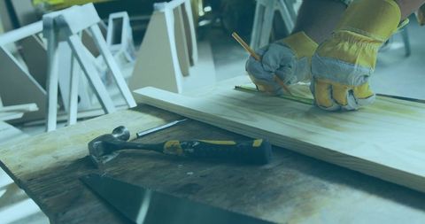 Carpenter’s hands measuring wood in workshop