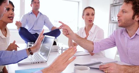 Businessman Meditating During Heated Office Argument - Download Free Stock Images Pikwizard.com