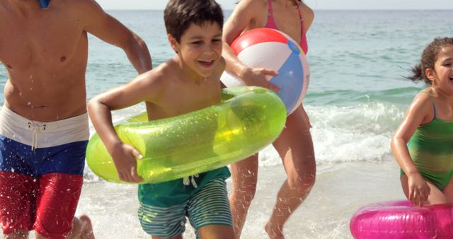 Family Enjoying Beach Day with Inflatable Toys and Beach Ball - Download Free Stock Images Pikwizard.com