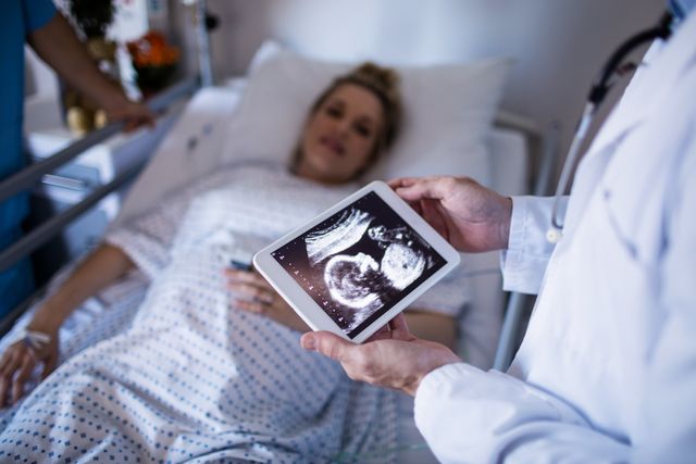 Male doctor looking at sonography report on a digital tablet in the hospital