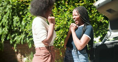 African american friends packing car for exciting summer road trip