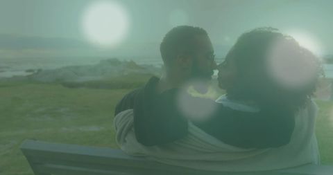 Romantic Embrace of Couple with Soothing Light Flare Over Ocean