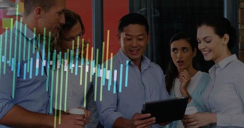 Colleagues analyzing tablet with colorful analytics overlay in modern workspace
