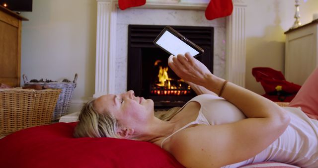 Relaxed Woman Reading on Tablet by Cozy Fireplace - Download Free Stock Images Pikwizard.com