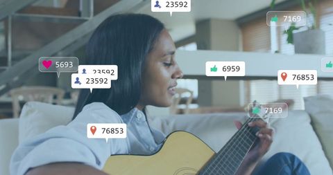 Biracial woman engaging with social media while playing guitar