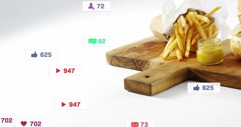 Crispy fries and burger on wooden board with floating social media engagement icons