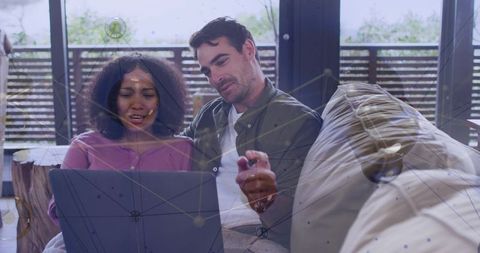 Couple collaborating on laptop at home with digital network overlay for remote work benefits