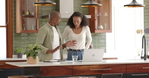 Couple Collaborating in Modern Kitchen with Laptop
