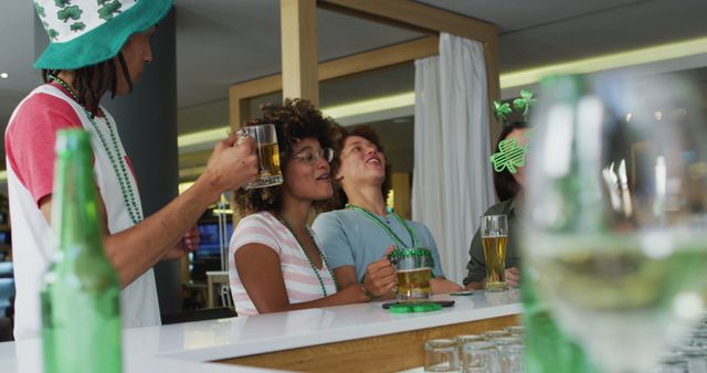 Friends are having a fun time at a bar, celebrating St. Patrick's Day with green-themed decorations and drinks. This image is perfect for use in advertisements for holiday events, party invitations, or social media campaigns promoting festive gatherings.
