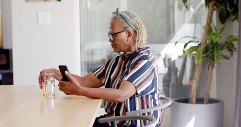 Senior Woman with Gray Hair Engaging on Smartphone at Home