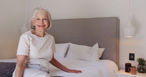 Senior Woman Relaxing with Mug in Modern Cozy Bedroom