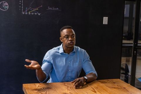 Business professional analyzing chalkboard data in modern meeting room