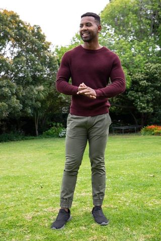 Smiling Man Enjoying Leisure Time in Lush Green Park Outdoors