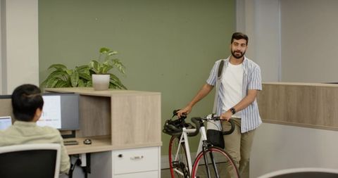 Professional entering modern office with bicycle
