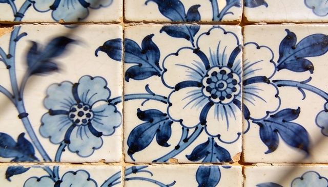 Featuring hand-painted blue floral ceramic tiles with crackle glaze and rustic grout