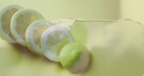 Diagonal lemon slices featuring whole lemon with soft double-exposure on pale yellow