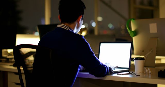 Young professional working late night on laptop in office - Download Free Stock Images Pikwizard.com