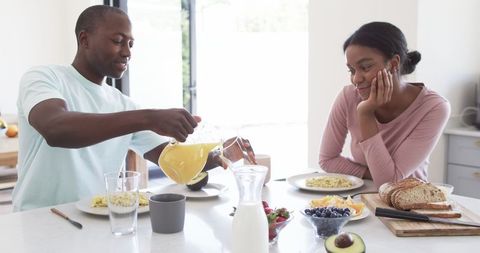 Happy Couple Enjoying Breakfast Together at Kitchen Table