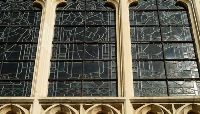 Gothic arched stained-glass bays with stone tracery, metal mullions and historic exterior