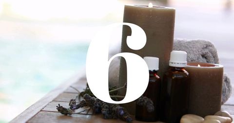 Coastal spa still life with number 6 overlay, lavender candles and aromatherapy oils