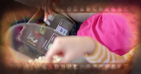 Teen girls using tablet and eating popcorn at home