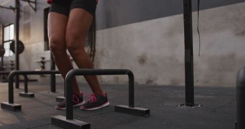 Woman training agility with parallel bars in gym setting
