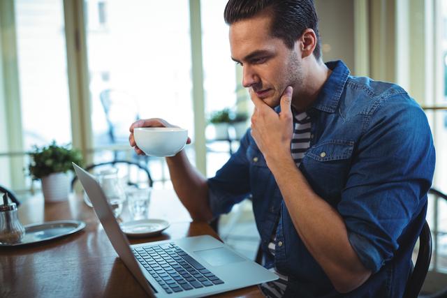 Man using laptop while having coffee - Download Free Stock Photos Pikwizard.com