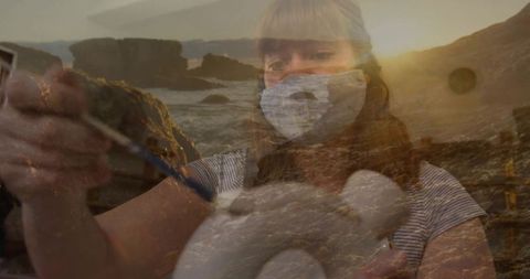 Masked artist paints pottery with ocean-inspired creativity