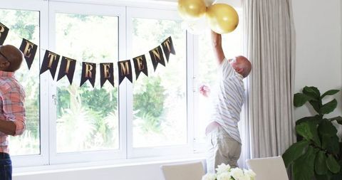 Setting up retirement party with gold balloons and banner