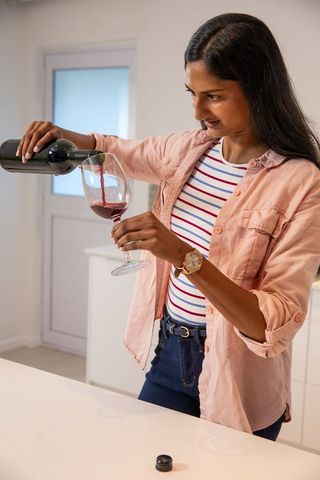 Woman Pouring Wine in Modern Home Kitchen