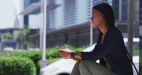 Confident Businesswoman Using Smartphone in Urban Environment