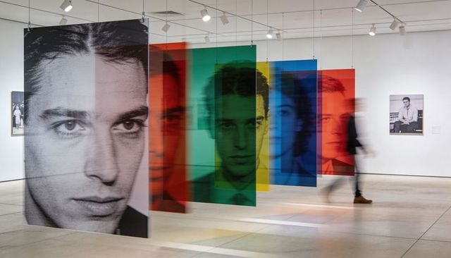 Hanging layered translucent portrait panels creating colorful contemporary gallery installation