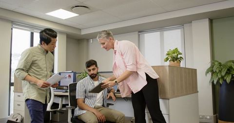 Diverse Team Collaborating on Tablet at Modern Office Workspace
