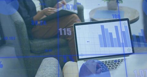 Analyzing business data on laptop with colleague in modern lounge workspace for teamwork