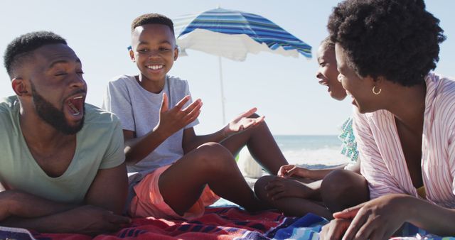 African American family relaxing and enjoying a picnic on the beach. Perfect for emphasizing family bonds, leisure activities, outdoor fun, and summer vacations. Great for advertisements, articles about family life, summer activities, and vacation destinations.