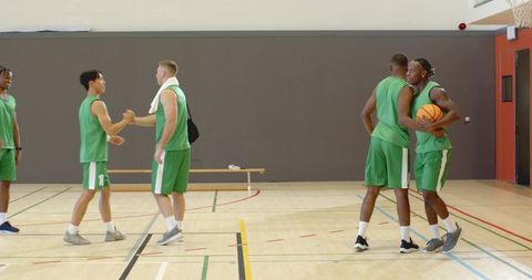 Multiracial basketball players showing sportsmanship, teamwork and training in indoor court