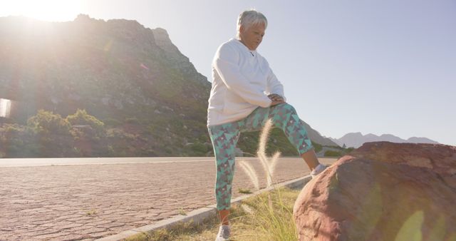 Senior Woman Stretching Outdoors in Mountaneous Landscape - Download Free Stock Images Pikwizard.com