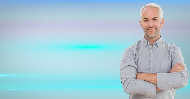 Image shows an elderly man with grey hair standing with arms crossed against a vibrant colorful gradient background. This can be used in lifestyle, positivity, self-confidence or modern senior lifestyle content. Ideal for adverts portraying mature audience confidence or casual fashion.