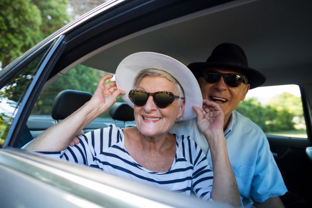 Senior couple enjoying a road trip, smiling and looking out of car window. Ideal for travel, retirement, and lifestyle content. Perfect for promoting senior travel packages, adventure tours, and family vacations.