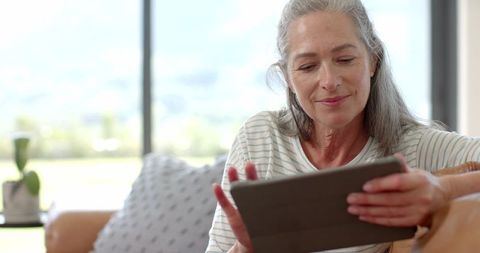 Senior Woman Using Tablet at Home in Relaxed Setting