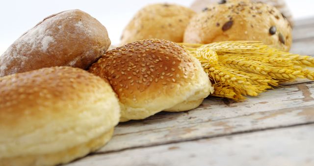Assorted Fresh Bread Rolls with Wheat Stalks on Rustic Wooden Surface - Download Free Stock Images Pikwizard.com