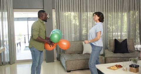 Couple Laughing with Balloons in Stylish Living Room
