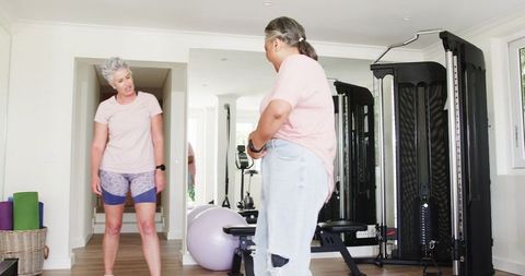 Senior Lesbian Couple Embracing in Home Gym Setting