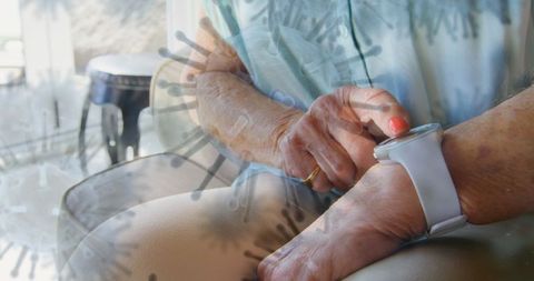 Senior using smartwatch for health monitoring at home