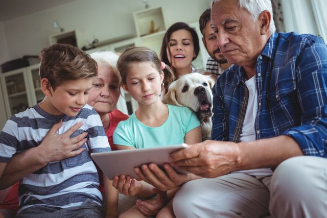 Multi-generation family using digital tablet in living room at home