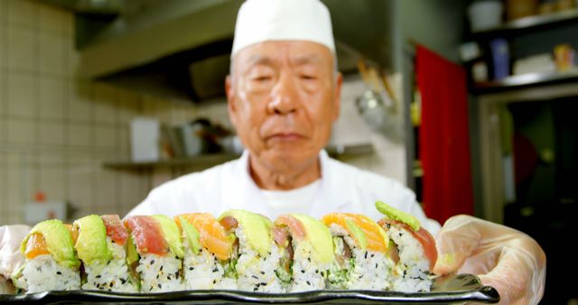 Experienced Chef Holding Freshly Prepared Sushi Roll in Modern Kitchen - Download Free Stock Images Pikwizard.com